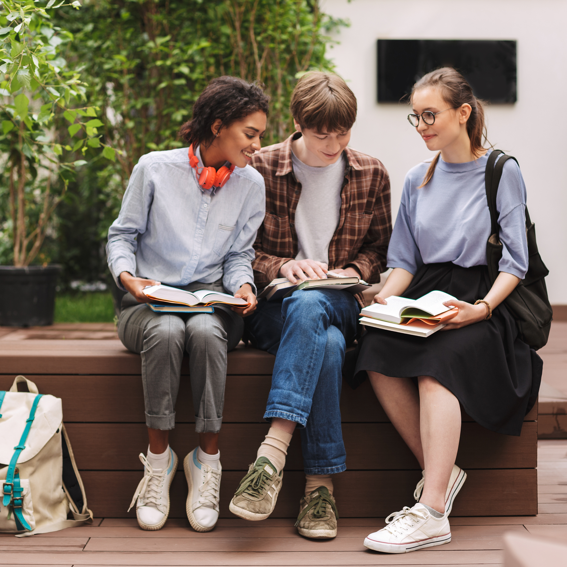 Three students sitting on a bench